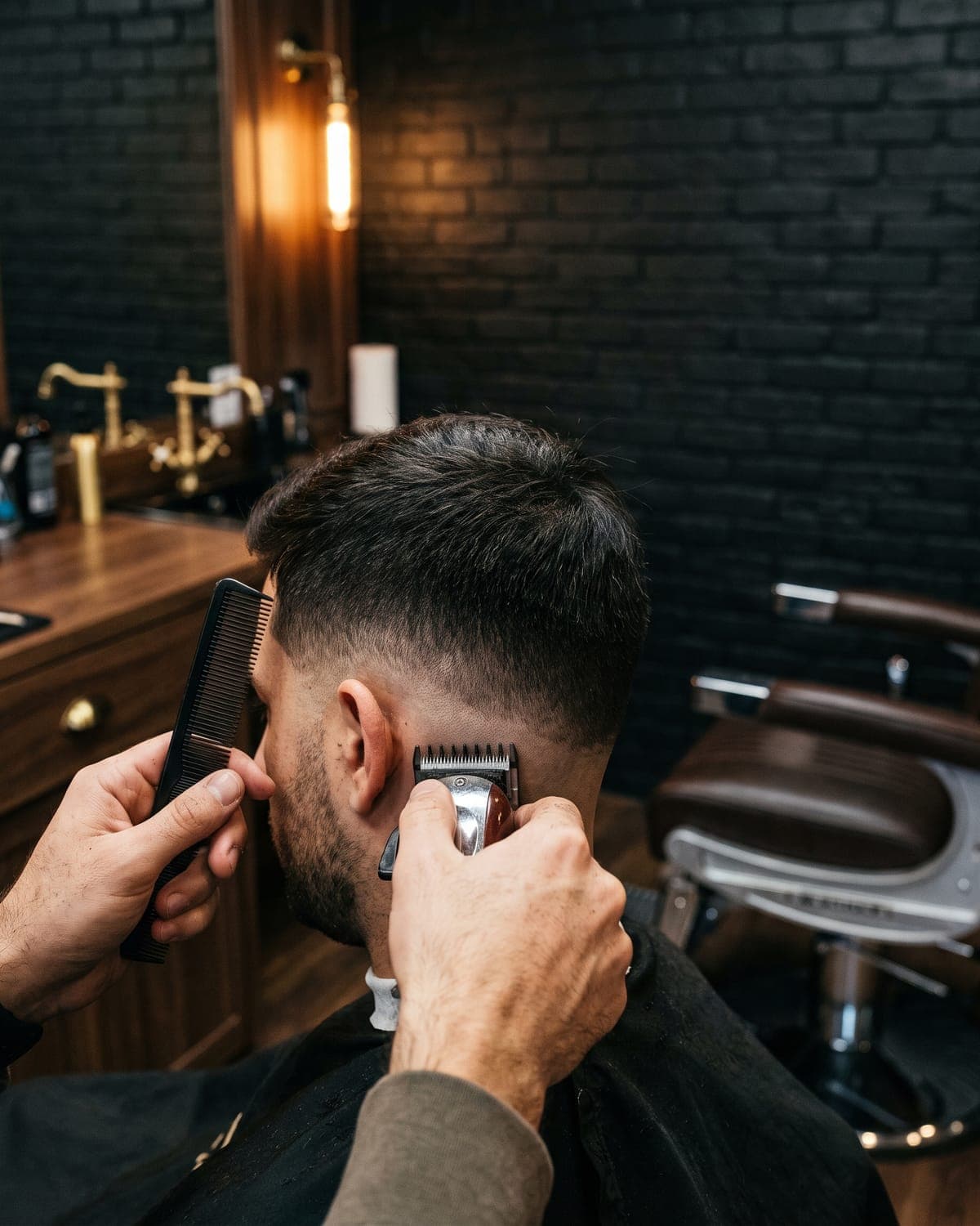 Clippers blending a skin fade at the back of a client’s head
